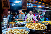 Männer, die auf einem nächtlichen Straßenmarkt in Indien Lebensmittel verkaufen,Noida,Uttar Pradesh,Indien