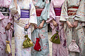 Frauen in traditioneller Kleidung mit ähnlich gestalteten Handtaschen in einem historischen Viertel von Kyoto, Japan, Kyoto, Japan