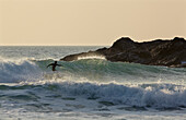 Surfen in der Constantine Bay bei Sonnenuntergang, in der Nähe von Padstow, Cornwall, Großbritannien, Cornwall, England