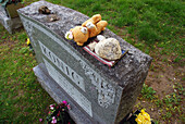 Ein mit Erinnerungsstücken geschmückter Grabstein am Memorial Day, Arlington, Massachusetts.