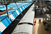 Erhöhte Ansicht eines Zuges, der im Bahnhof Mahim in Mumbai, Indien, Mumbai, Maharashtra, Indien einfährt