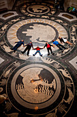 Tour group lays in a row on the decorative Rotunda floor in the Nebraska State Capitol and looks up to admire the ceiling,Lincoln,Nebraska,United States of America