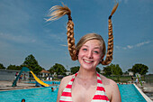 Teenage girl's braids stand on end at an outdoor swimming pool,Greenleaf,Kansas,United States of America