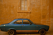 Blauer Sportwagen an einer verwitterten Mauer geparkt, Mdina, Insel Malta, Republik Malta