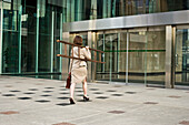 Businesswoman Entering Building,Holding Ladder