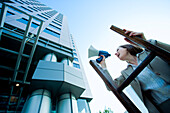 Businesswoman Standing on Ladder using Bullhorn