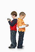 Boys with Handheld Video Games Standing Back to Back