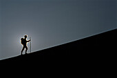 Silhouette einer Person beim Wandern in den Mesquite Dunes, Death Valley, Kalifornien, USA