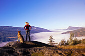 Mädchen und Hund auf dem Gipfel eines Berges
