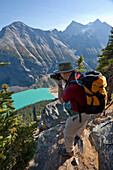 Wanderer, der den Lake Louise vom Big Beehive aus fotografiert, Banff National Park, Alberta, Kanada