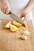 Frau schneidet Zitronen und Knoblauch