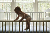 Babyjunge klettert aus dem Bettchen