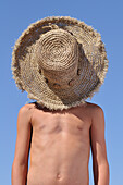 Boy with Straw Hat over Face