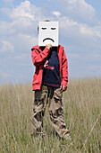 Boy in Field Holding Frown Face