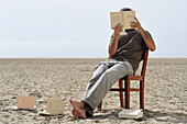Man Reading Books on the Beach