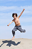 Little Boy Jumping on the Beach