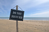 Schild "Bitte nicht stören" am Strand