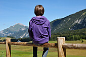 Back View of Boy Sitting on Wooden Fence,Glieres Plateau,Alps,France