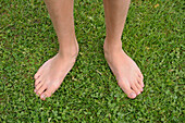 Nahaufnahme eines Jungen mit nackten Füßen auf Gras,Alpen,Frankreich