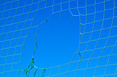 Close-up of Hole in Net against Blue Sky
