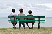 Back View of Mother and Sons Sitting on Park Bench,Ile de Re,France