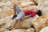 Junge auf Felsen liegend,Ile de Re,Frankreich