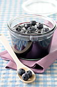 Close-up of Homemade Blueberry Jam with fresh Blueberries on Top with Wooden Spoon