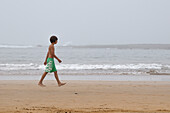 Junge geht am Strand spazieren, Rabat, Marokko