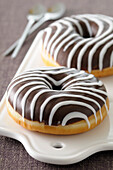 Close-up of Chocolate Dipped Donut with Vanilla Stripes on Cutting Board,Studio Shot