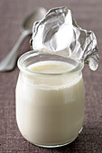 Close-up of Foil Lid opened on Single Serving Yoghurt on Grey Background,Studio Shot