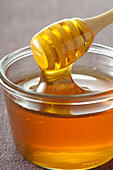 Nahaufnahme eines Honiglöffels in einer Schale mit Honig