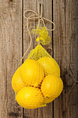 Beutel mit Zitronen an der Wand hängend