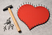 Nails outlinging large,wooden heart and hammer