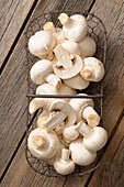 mushrooms in wire basket on wooden background,studio shot