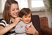 Teenage Girl with Baby Boy Listening to MP3 Player,Mannheim,Baden-Wurttemberg,Germany