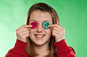 Teenage Girl Holding Condoms Over Eyes