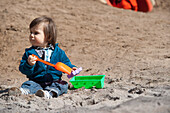Kleiner Junge spielt im Sand