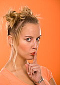 Frau mit Finger an den Lippen