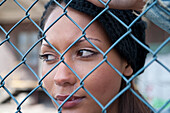 Woman Crying behind Fence