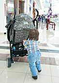 Baby Boy Pushing Stroller in Shopping Mall,Mexico
