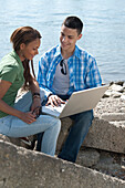 Couple using Laptop at Beach