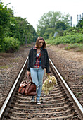 Mädchen im Teenageralter geht auf Eisenbahnschienen