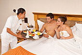 Couple being Served Breakfast in Bed in Hotel