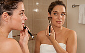 Woman Applying Make-up in Bathroom,Reef Playacar Resort and Spa,Playa del Carmen,Mexico