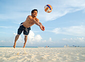 Mann beim Volleyballspielen am Strand,Mexiko