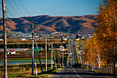 Rural autumn landscape,Highway with autumnal forest hills,Hokkaido,Japan,Asia