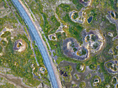 Luftaufnahme eines alten Vulkans und einer asphaltierten Straße in der Nähe des Myvatn-Sees an einem Sommertag, Island, Polarregionen