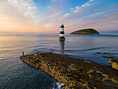 Fischer am Trwyn Du Leuchtturm bei Sonnenuntergang im Sommer, Beaumaris, Wales, Großbritannien, Vereinigtes Königreich, Europa