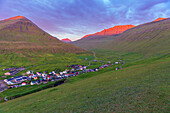Früher Morgen im Dorf Gjogv mit den von der Sonne beleuchteten Berggipfeln, Insel Eysturoy, Färöer Inseln, Dänemark, Europa