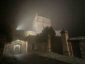 The tower and gate of a medieval castle in a small town during a winter night with fog,Castello di Seravalle,Emilia Romagna,Italy,Europe